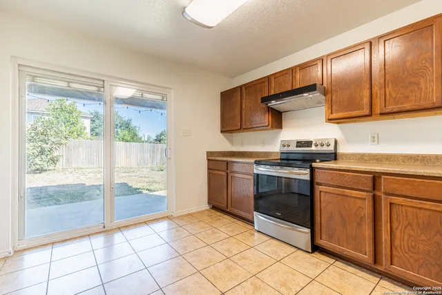a kitchen with stainless steel appliances granite countertop a stove a sink and a refrigerator
