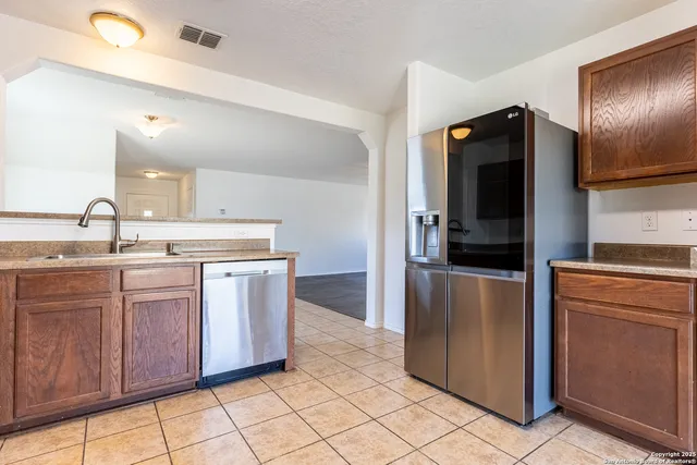 a kitchen with stainless steel appliances granite countertop a refrigerator and a sink