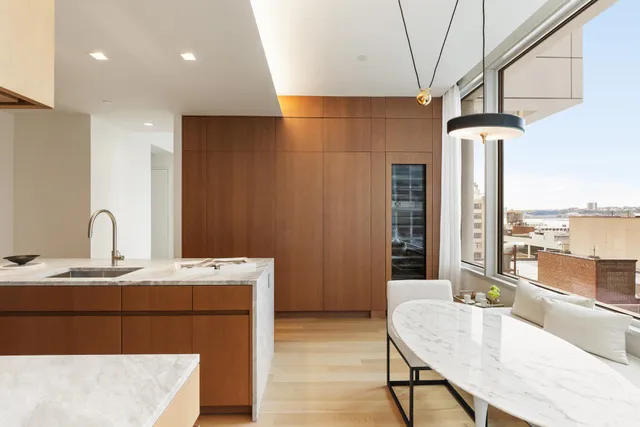 a spacious bedroom with a bed a window and a chandelier