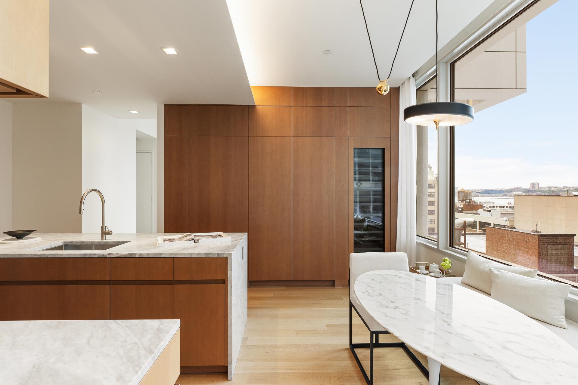 611 West 56th Street, Unit 12 Manhattan, NY 10019 - Photo 4 of 24 a dining hall with stainless steel appliances granite countertop a sink dishwasher and a refrigerator with wooden floor