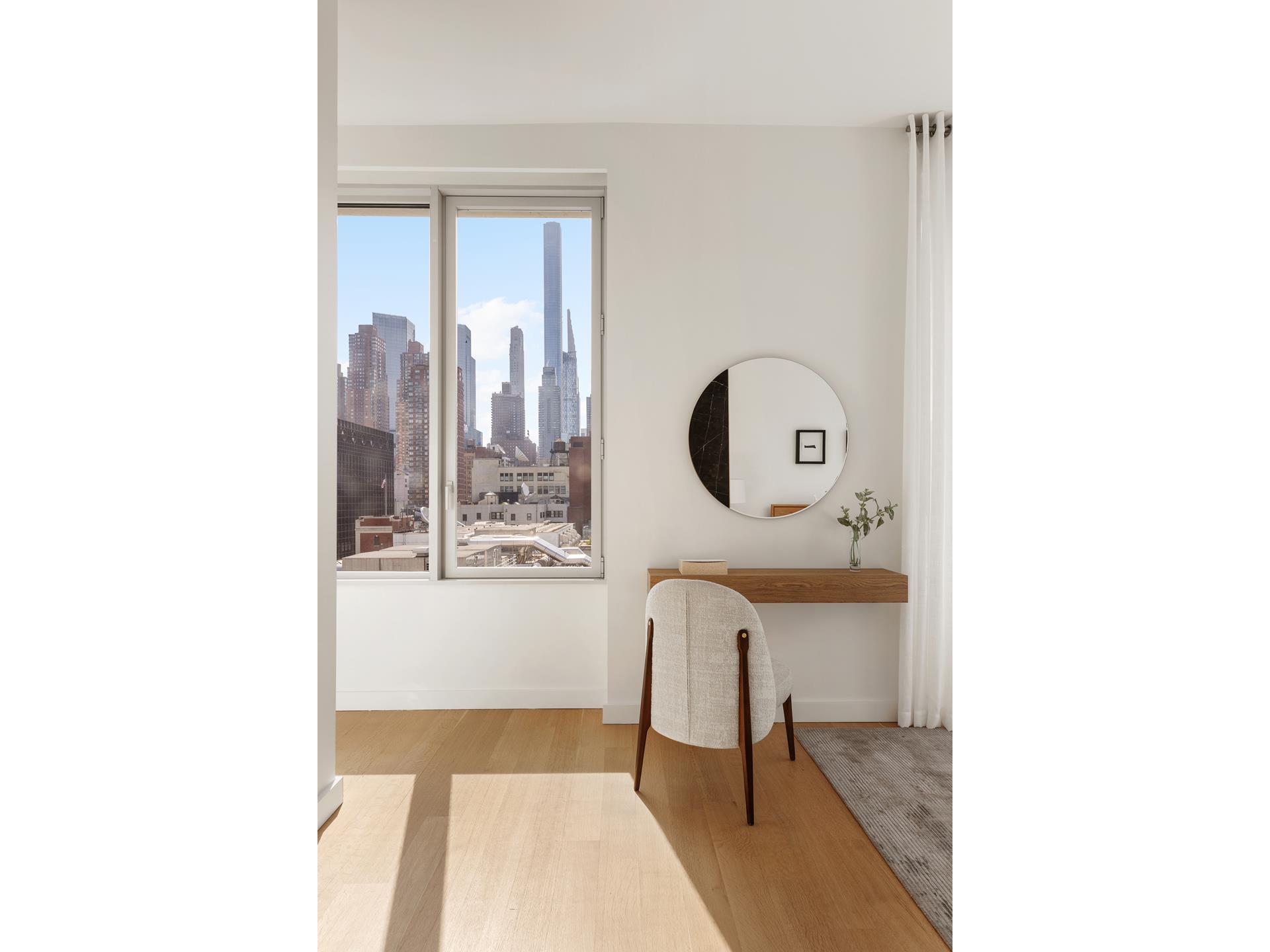 611 West 56th Street, Unit 12 Manhattan, NY 10019 - Photo 5 of 24 a living room with furniture and a mirror