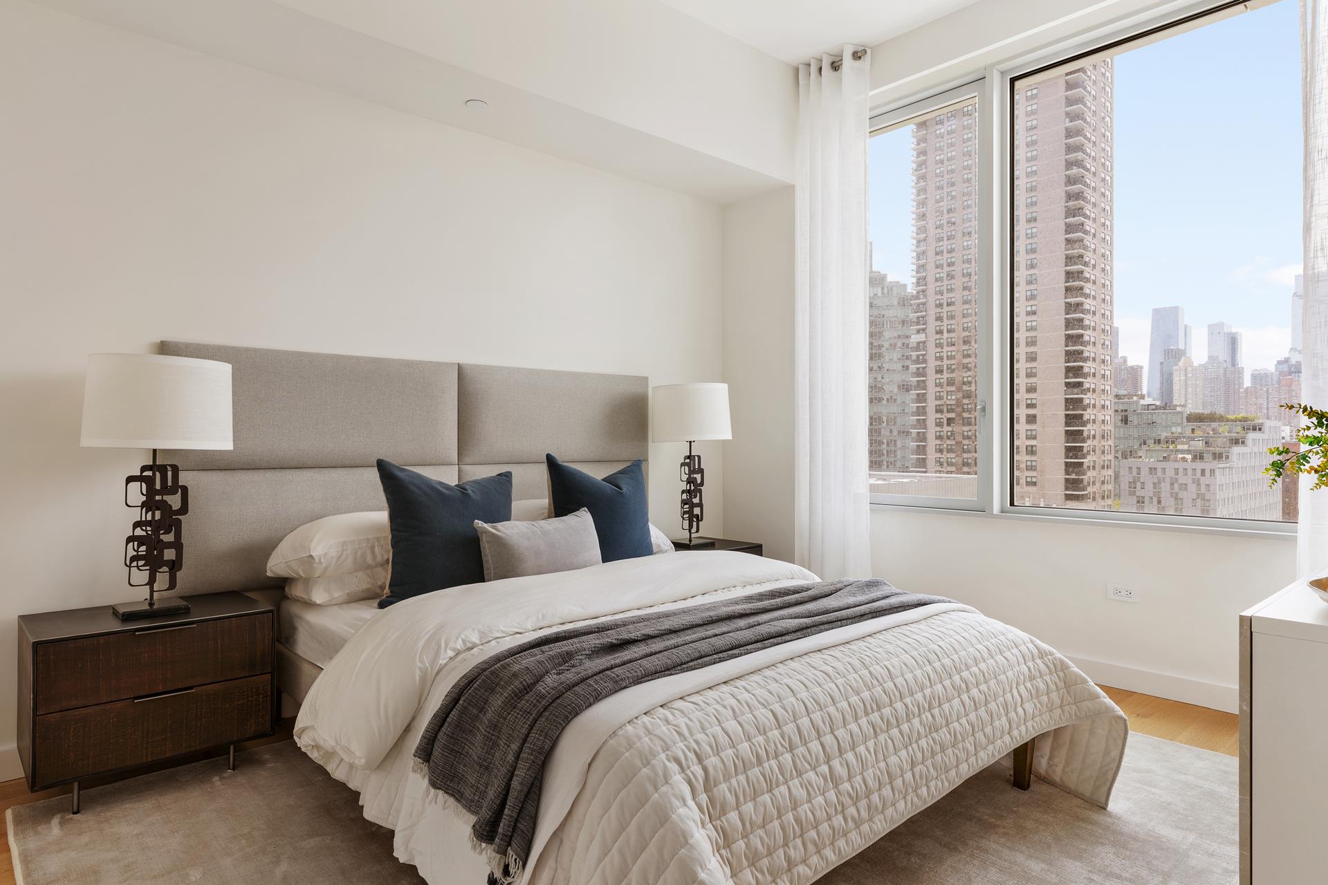 611 West 56th Street, Unit 12 Manhattan, NY 10019 - Photo 6 of 24 a bedroom with a bed and a large window