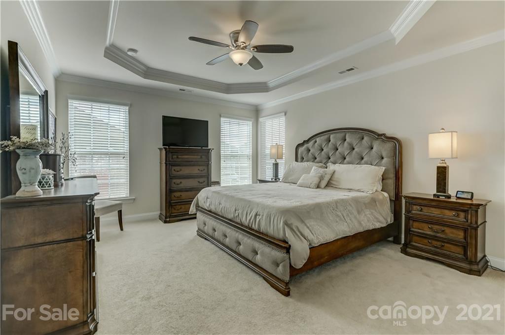 2016 Henslow Trail Tega Cay, SC 29708 - Photo 14 of 33 a spacious bedroom with a bed and a chandelier