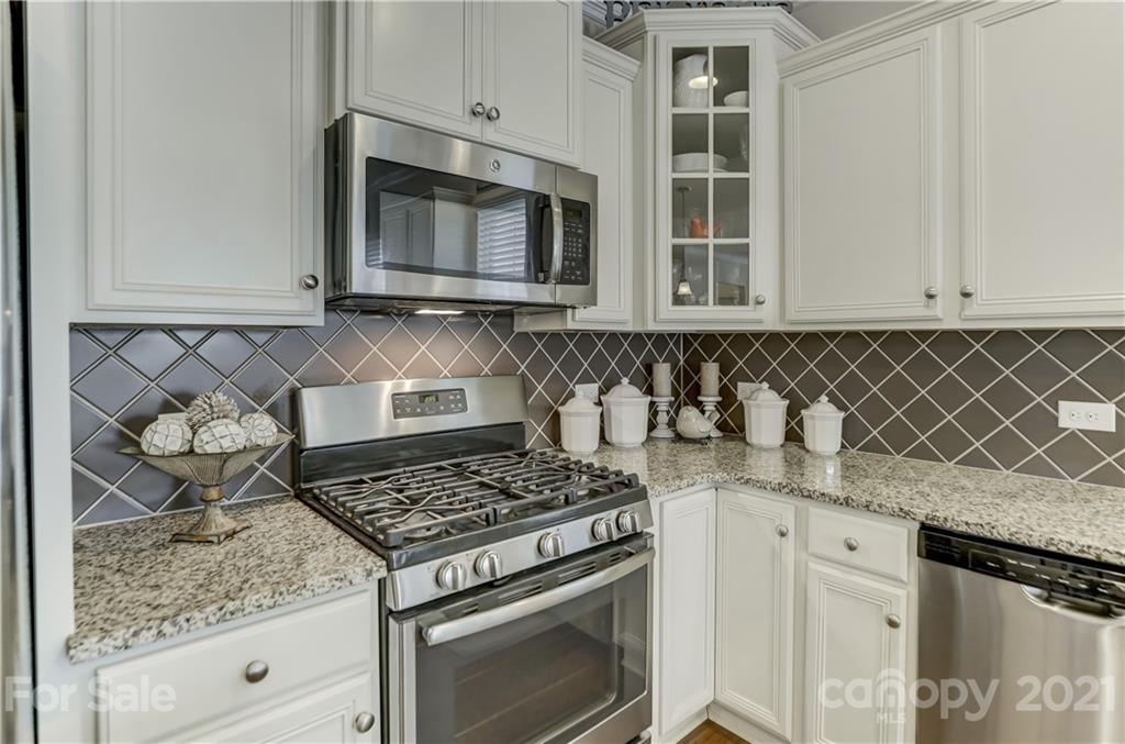 2016 Henslow Trail Tega Cay, SC 29708 - Photo 8 of 33 a kitchen with granite countertop white cabinets and black appliances