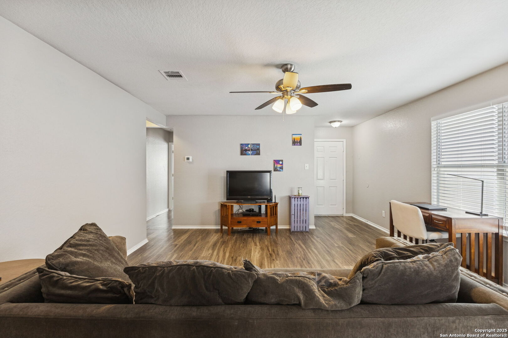 8919 Kestrel Oak Converse, TX 78109 - Photo 21 of 24 a living room with furniture and a flat screen tv with kitchen view