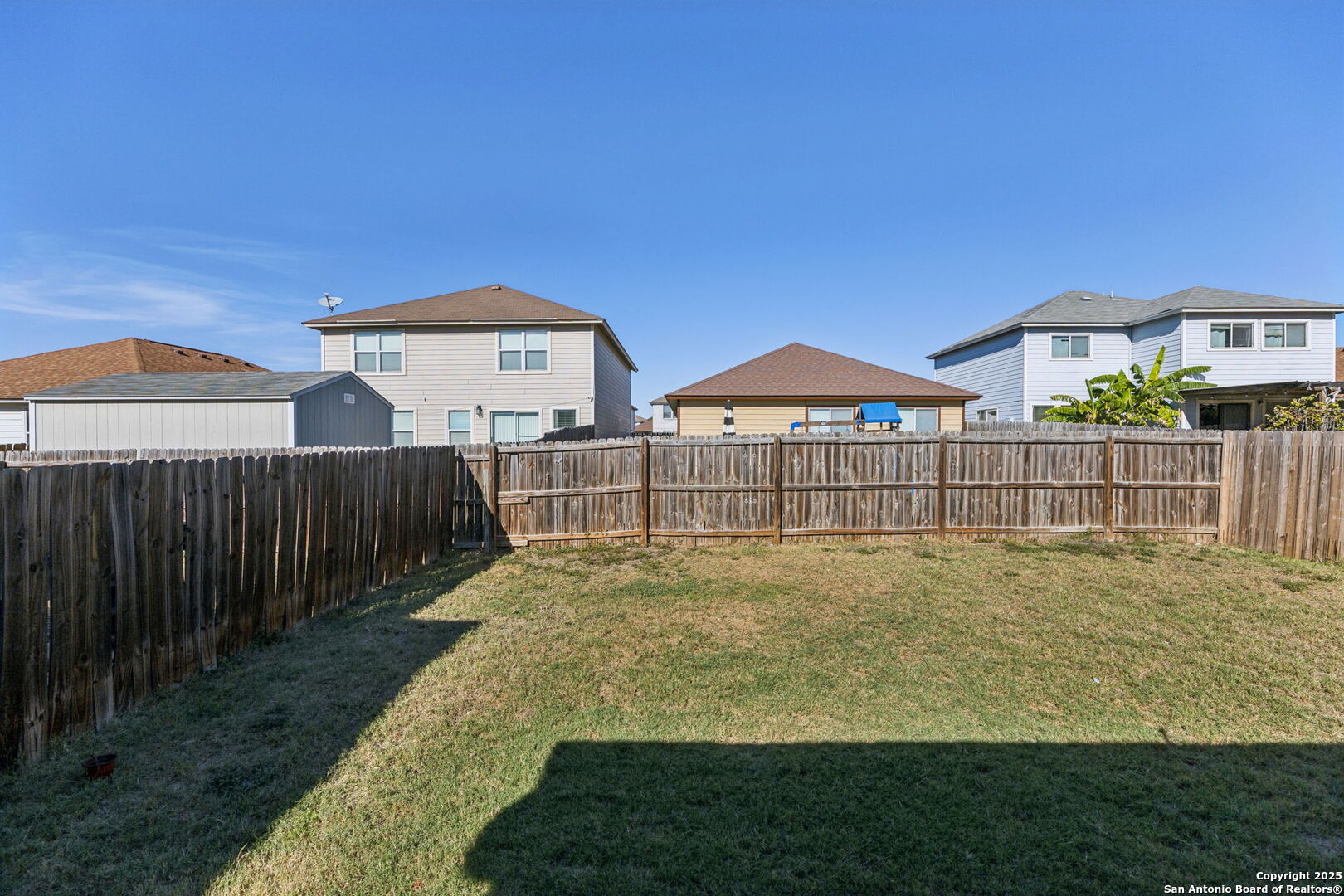 8919 Kestrel Oak Converse, TX 78109 - Photo 6 of 24 a view of a house with a yard and table under an umbrella