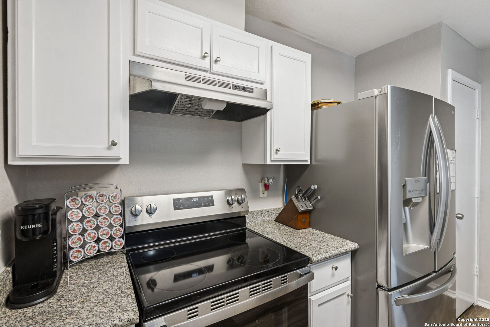 8919 Kestrel Oak Converse, TX 78109 - Photo 10 of 24 a kitchen with stainless steel appliances granite countertop a refrigerator and a stove top oven