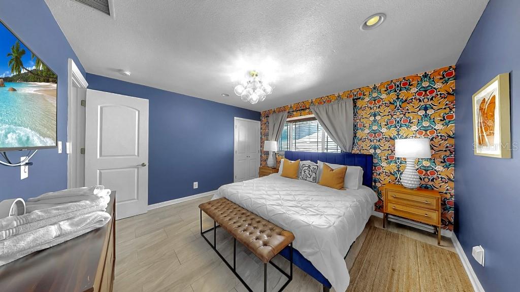 1004 Sago Palm Way Apollo Beach, FL 33572 - Photo 12 of 25 a bedroom with a bed and a chandelier