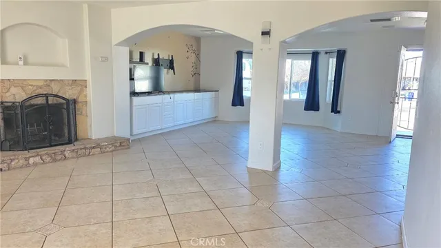 a view of a hallway with entryway wooden floor and a kitchen