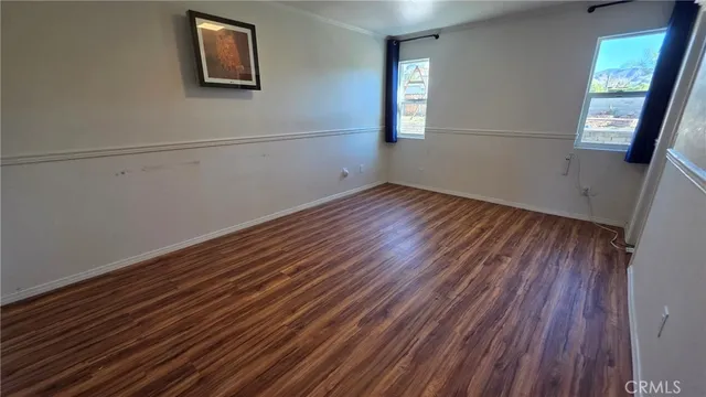 a view of a room with wooden floors and window
