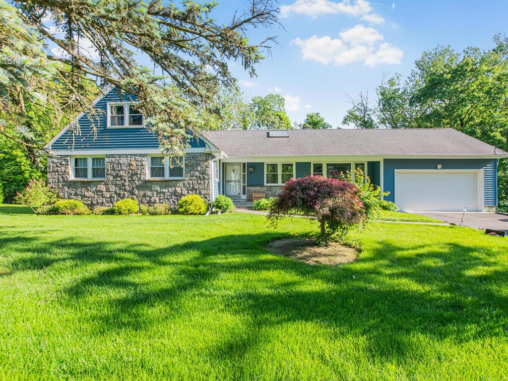 81 Winding Brook Road New Rochelle, NY 10804 - Photo 1 of 1 View of front of home featuring an attached garage, stone siding, and a front yard