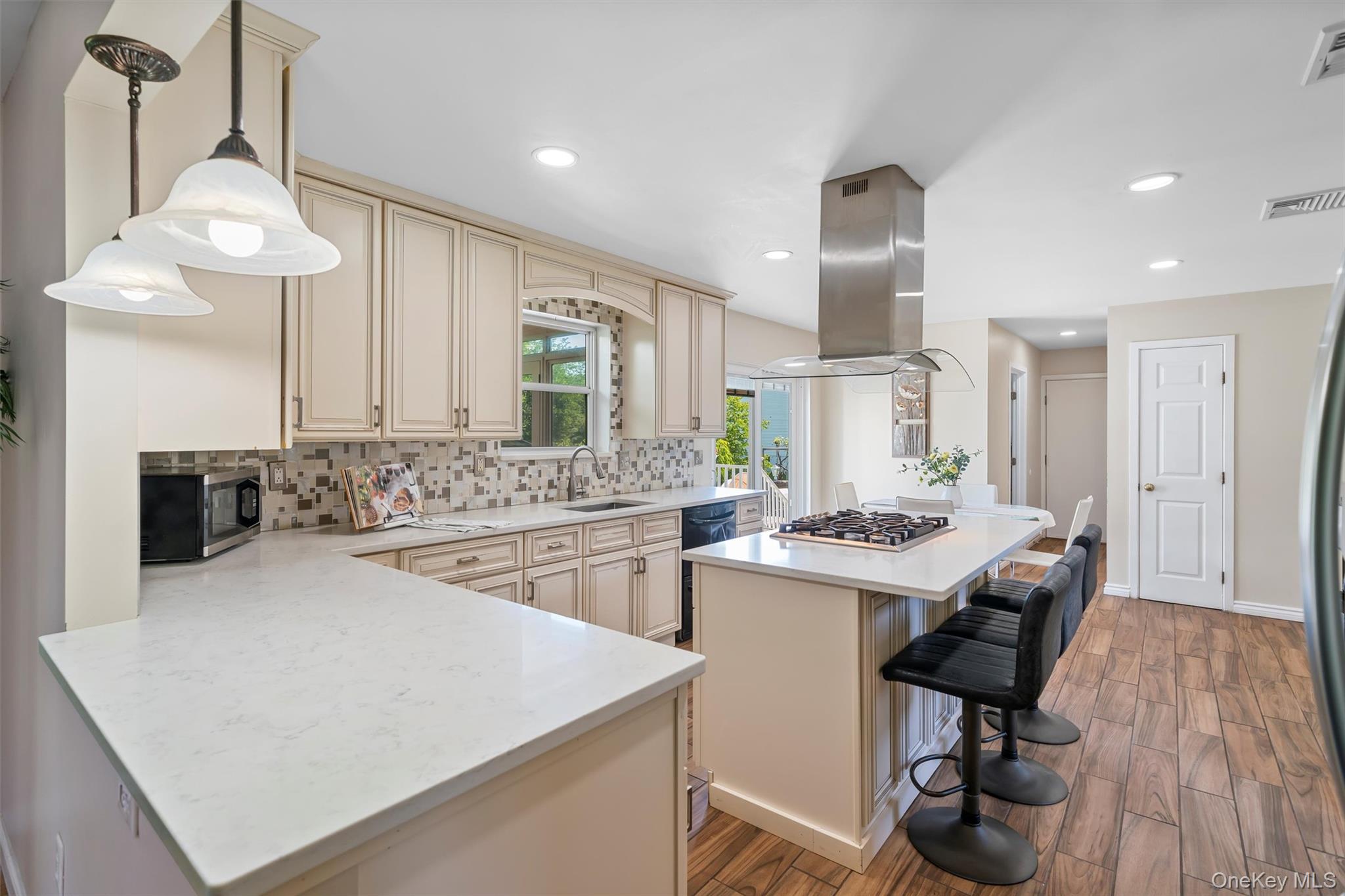 36 Lexington Drive Newburgh, NY 12550 - Photo 11 of 50 Kitchen with cream cabinetry, appliances with stainless steel finishes, island range hood, a sink, and decorative backsplash