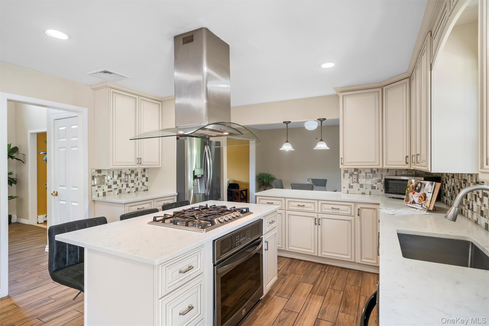 36 Lexington Drive Newburgh, NY 12550 - Photo 14 of 50 Kitchen with stainless steel appliances, island exhaust hood, a sink, light wood-type flooring, and backsplash