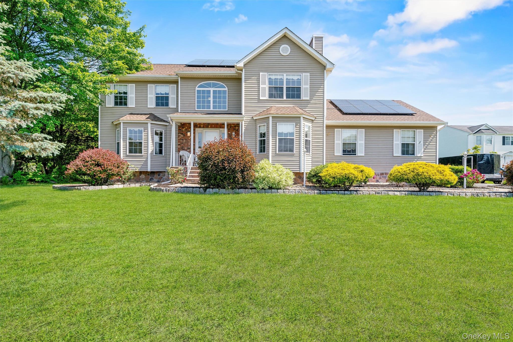 36 Lexington Drive Newburgh, NY 12550 - Photo 2 of 50 View of front of home with solar panels, a chimney, and a front lawn