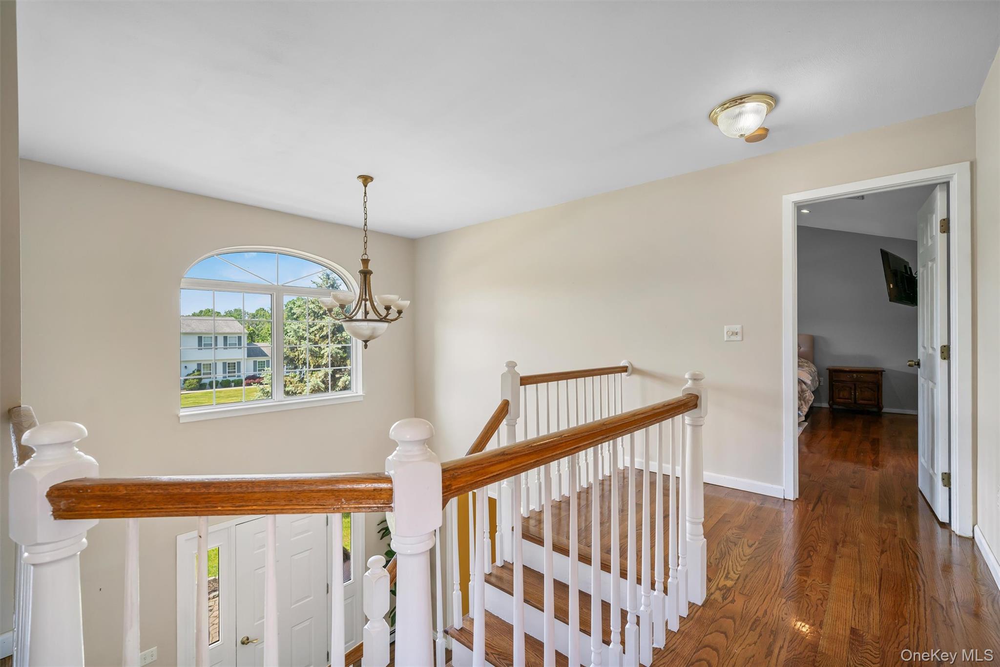 36 Lexington Drive Newburgh, NY 12550 - Photo 24 of 50 Hallway with an upstairs landing, dark wood finished floors, a chandelier, and baseboards