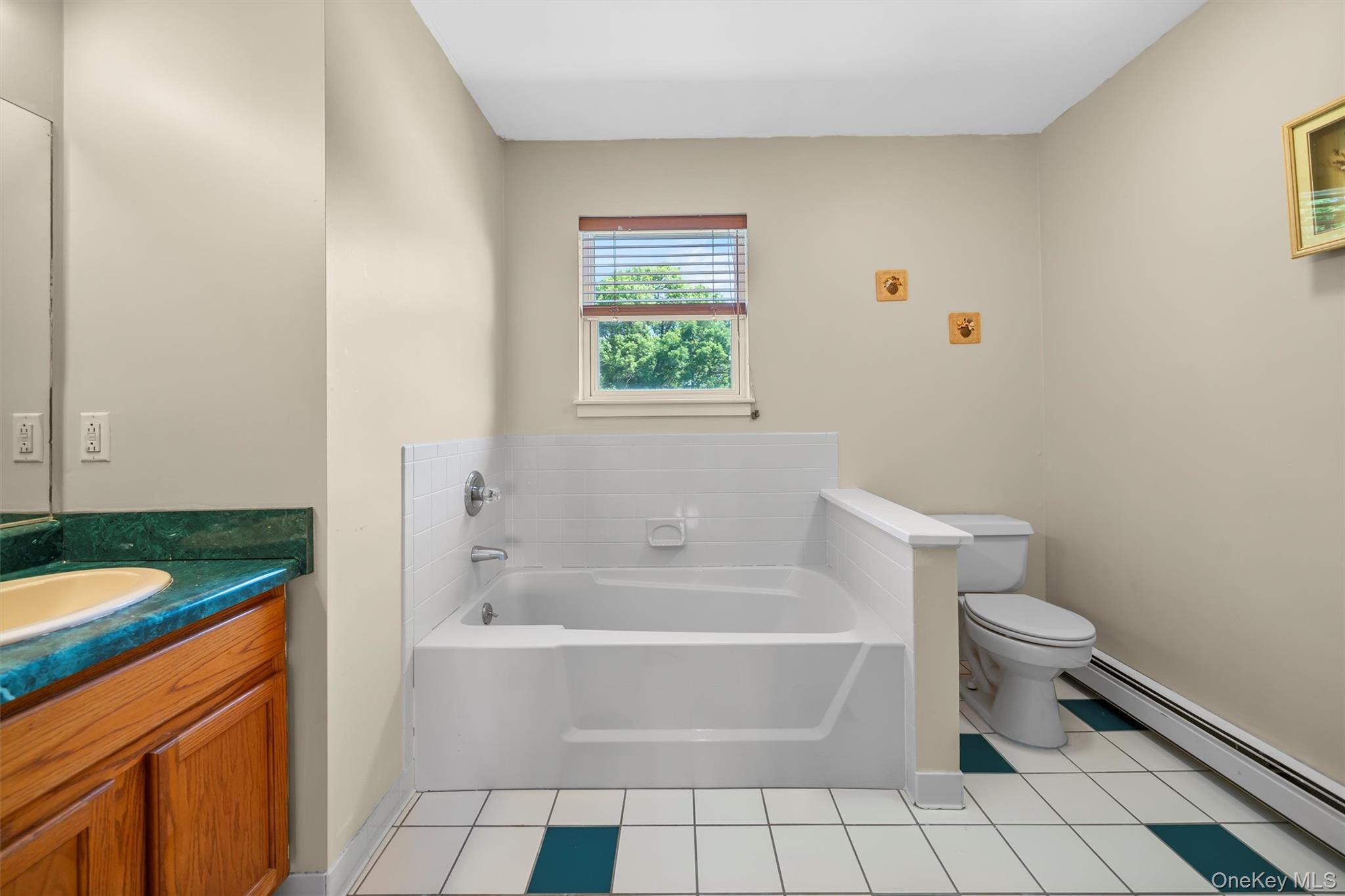 36 Lexington Drive Newburgh, NY 12550 - Photo 28 of 50 Bathroom featuring a baseboard radiator, toilet, a garden tub, vanity, and tile patterned flooring