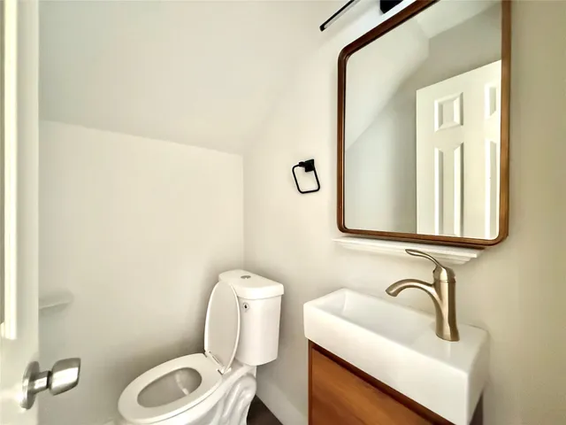 a bathroom with a sink mirror vanity and toilet