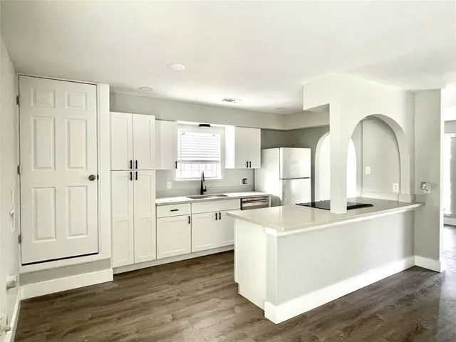 a large white kitchen with cabinets