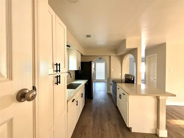 a view of a kitchen with a sink wooden floor and windows
