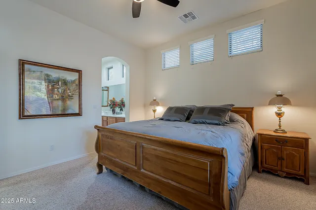 a bedroom with a bed and a lamp on the dresser