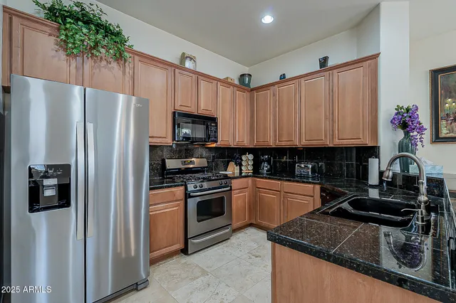 a kitchen with granite countertop a refrigerator stove and sink