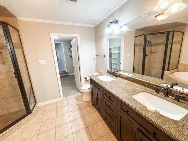 a bathroom with a granite countertop sink a mirror and a shower