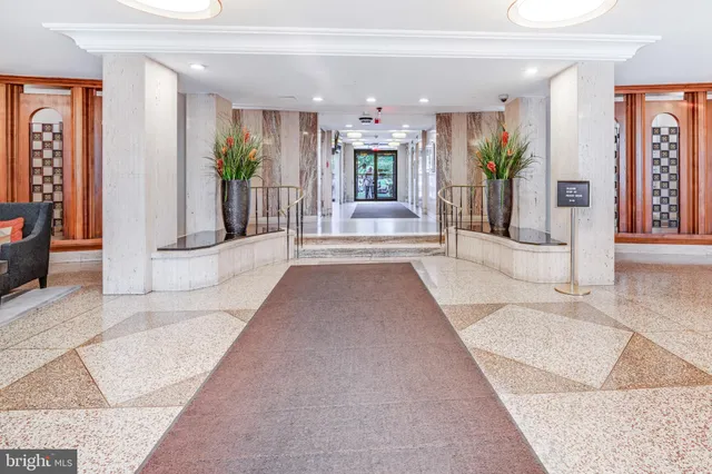 a view of a hallway with dining area and chandelier
