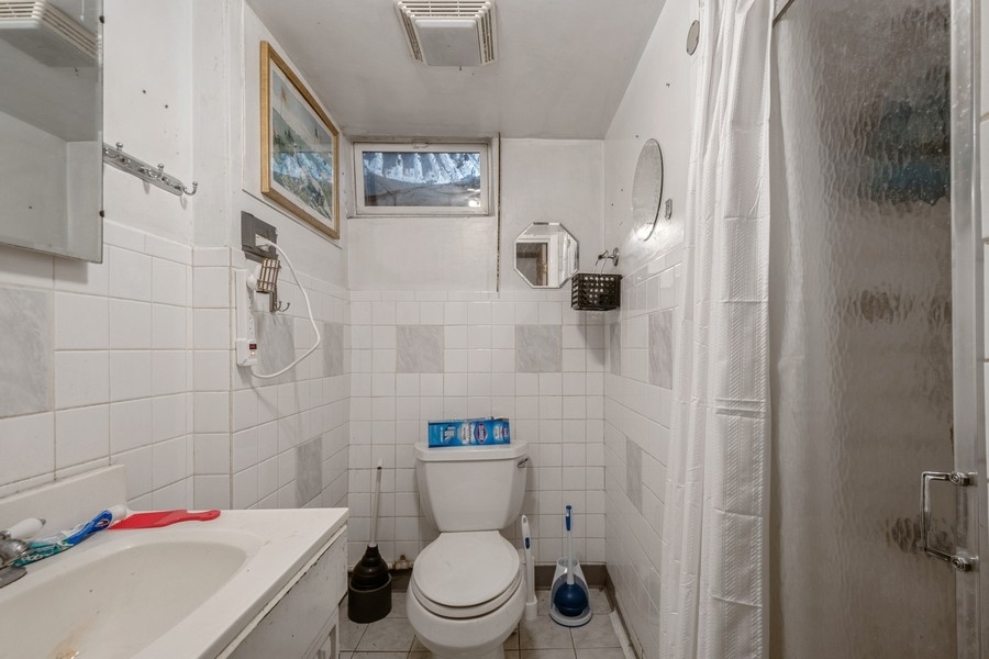 8645 Frontage Road Skokie, IL 60077 - Photo 6 of 13 a white toilet sitting next to a bathroom sink