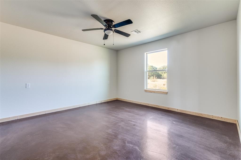 19148 Cabo Way, Unit 19152 Thackerville, OK 73459 - Photo 13 of 19 an empty room with wooden floor fan and windows