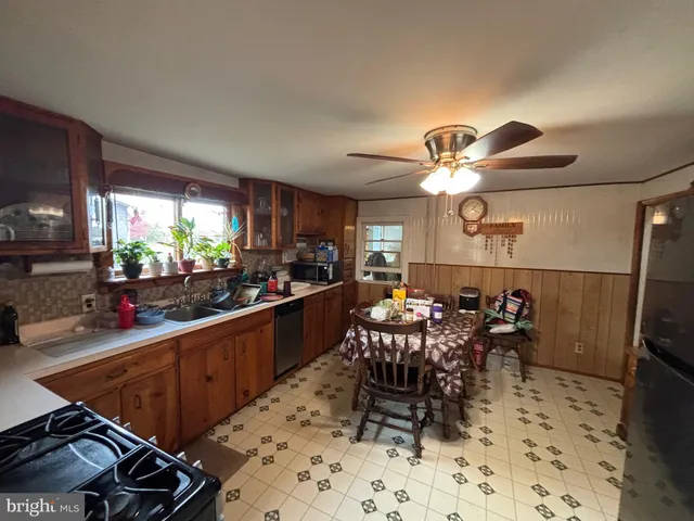 a kitchen with stainless steel appliances a dining table and chairs