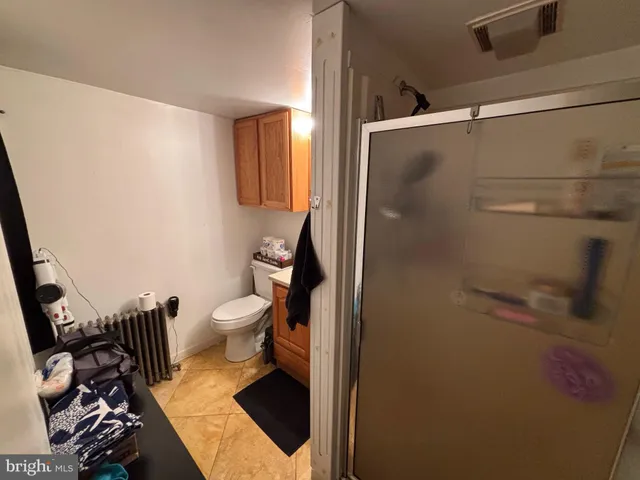 a bathroom with a granite countertop toilet and a sink