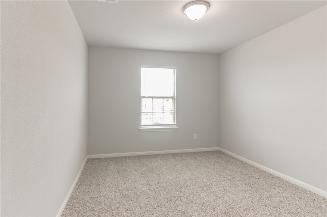 129 Wild Wind Trail Jarrell, TX 76537 - Photo 19 of 27 Bedroom #4 is also upstairs in the front of the house. It has a walk in closet. Bedrooms 3 and 4 could also be a good home office if you do not need 5 bedrooms. Also could great storage place. Carpet has been removed and replaced with luxury vinyl planks,