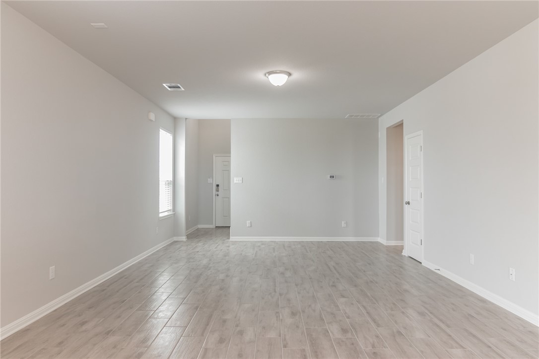 129 Wild Wind Trail Jarrell, TX 76537 - Photo 8 of 27 View of family room from breakfast bar. Stairs and closet are behind the wall in background.