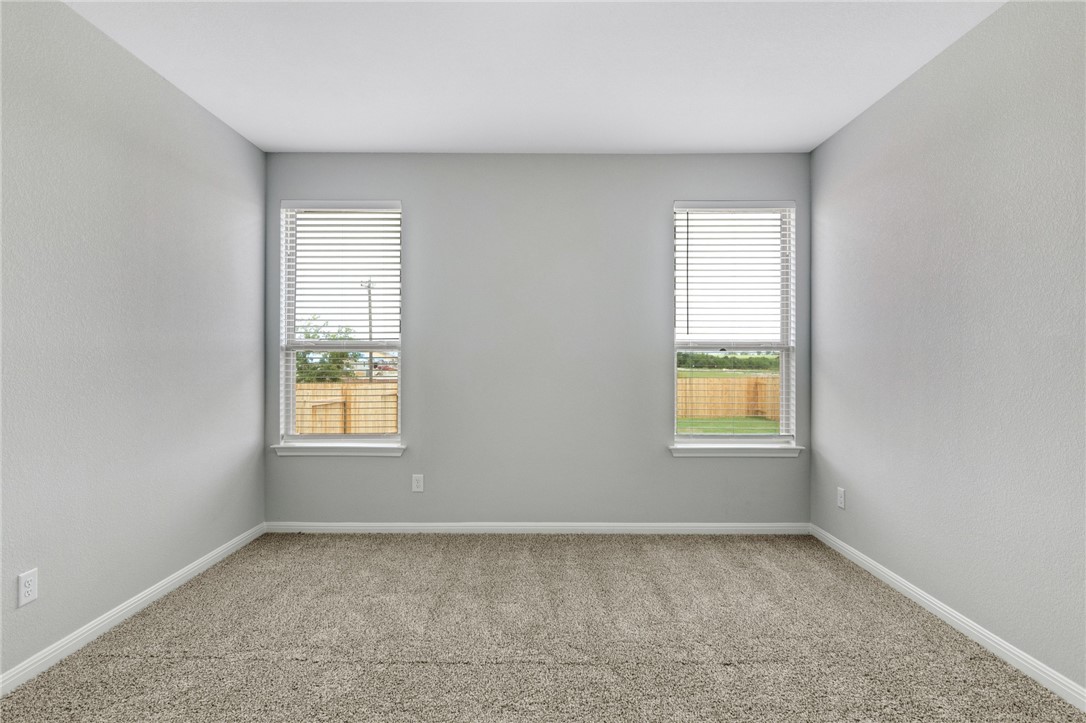 129 Wild Wind Trail Jarrell, TX 76537 - Photo 10 of 27 Primary bedroom is just off of the kitchen. The carpet has been removed and replaced with luxury vinyl plank flooring