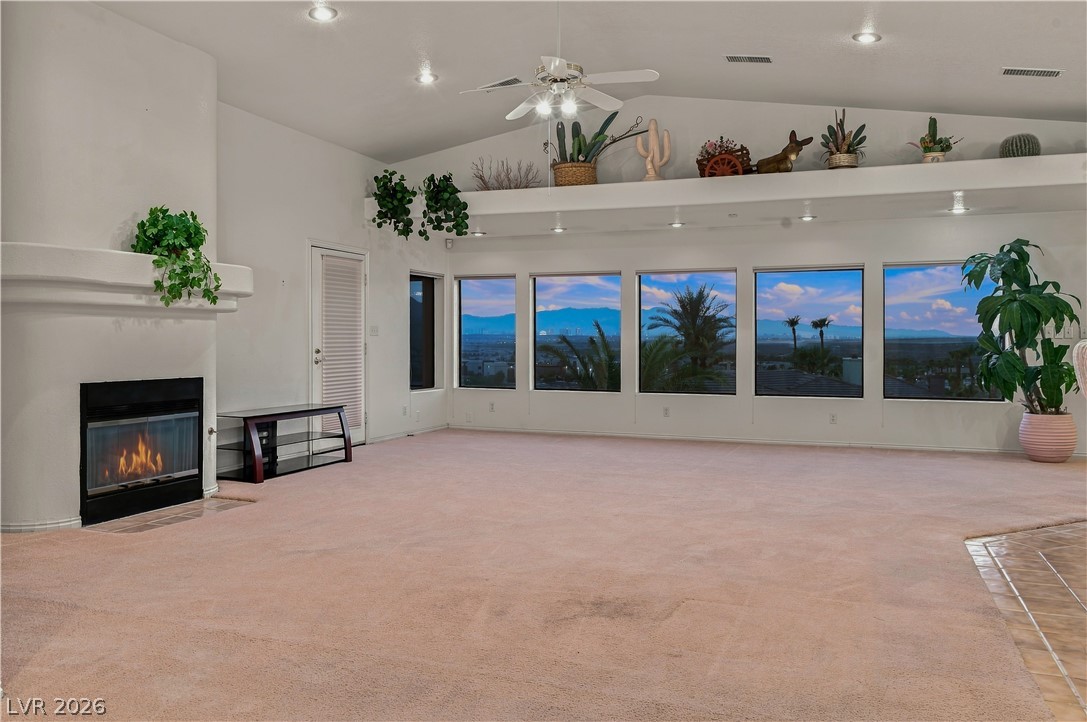 1068 Calico Ridge Drive Henderson, NV 89011 - Photo 11 of 38 High vaulted ceilings and a classic fireplace anchor this spacious, carpeted living area.