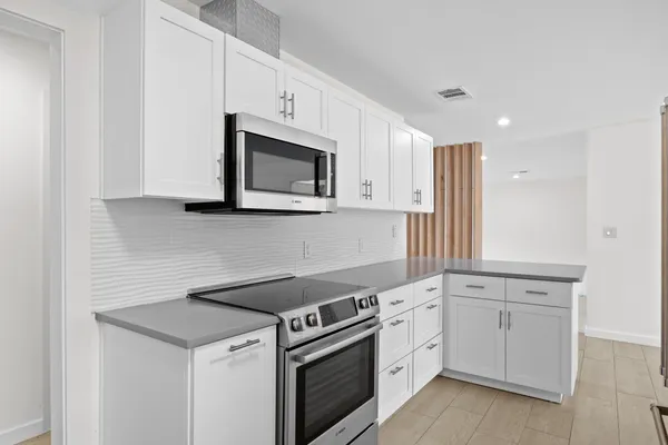 a kitchen with white cabinets stainless steel appliances and sink