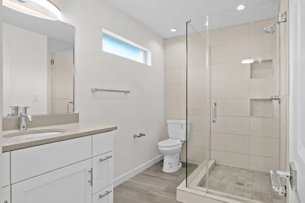 a bathroom with a sink toilet a mirror and shower