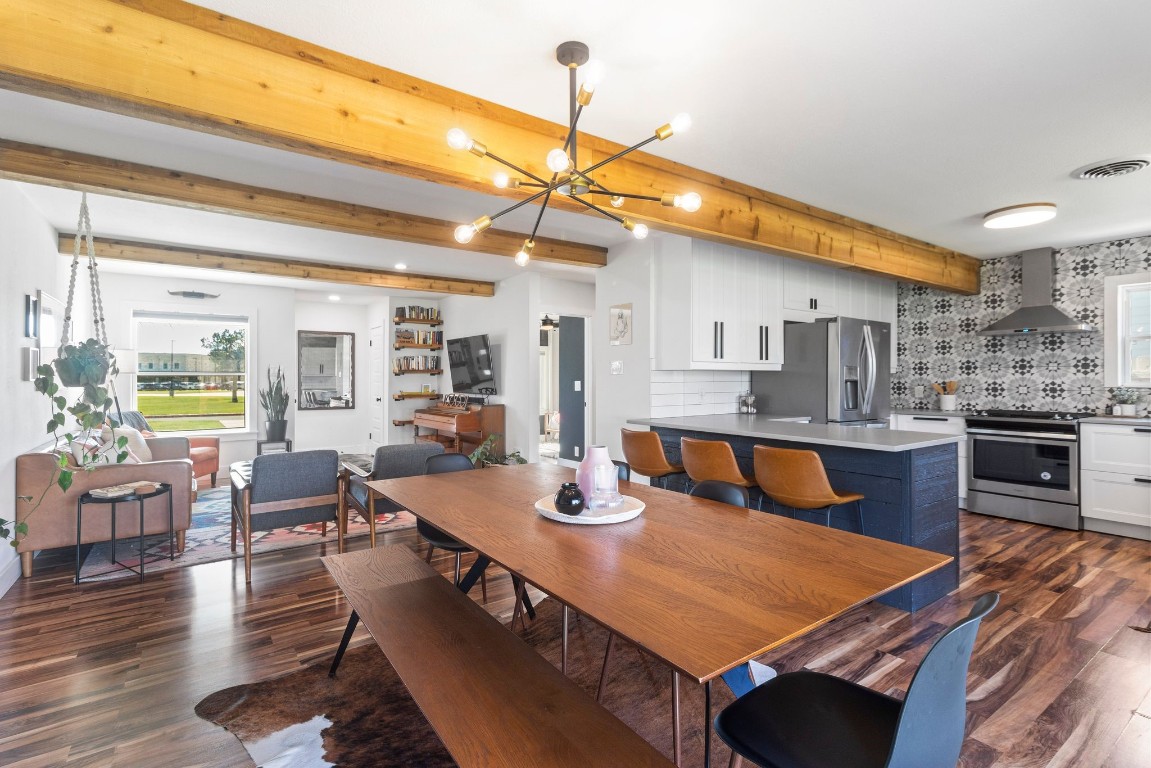 a dining hall with stainless steel appliances granite countertop a dining table and chairs with wooden floor