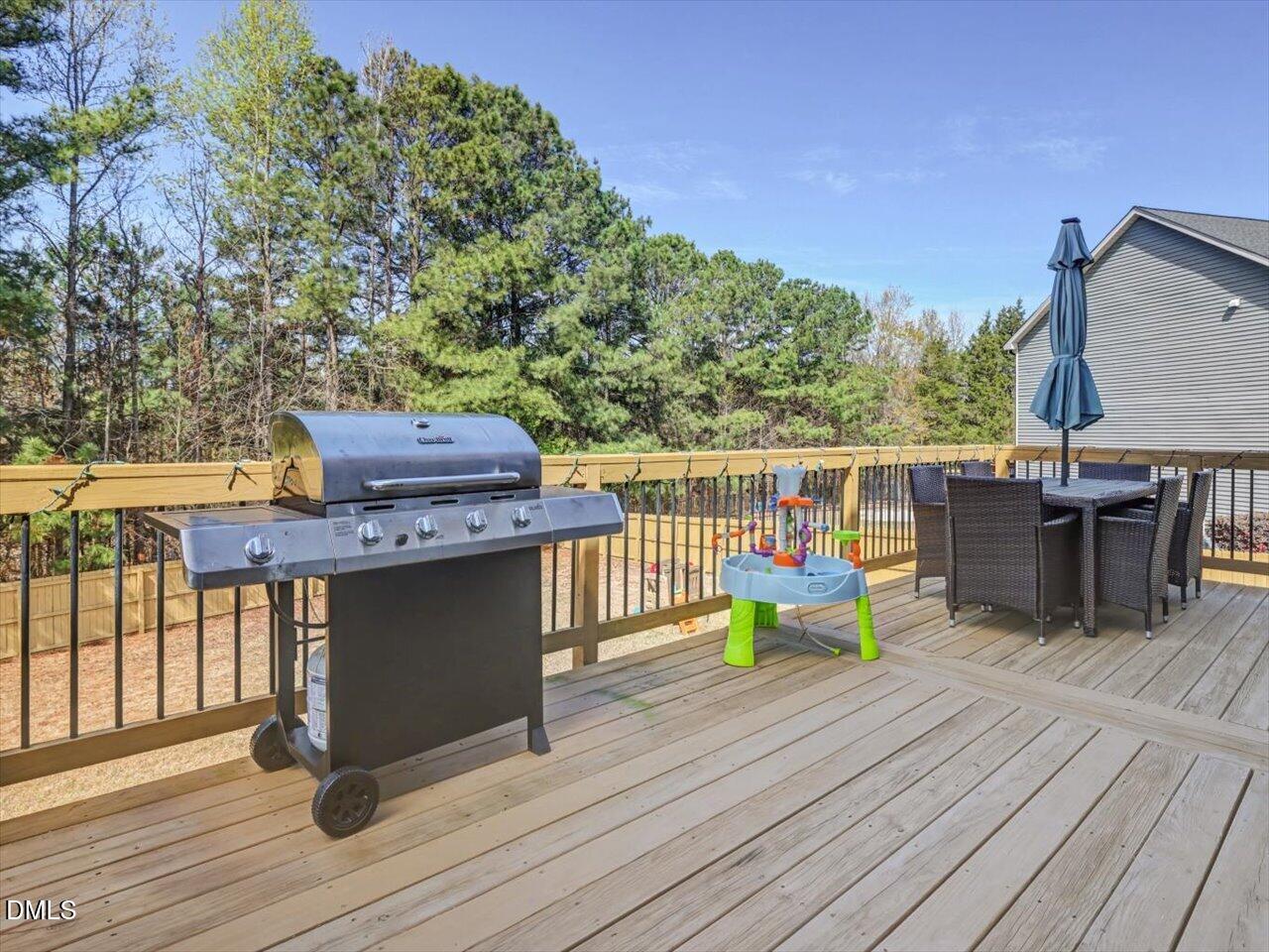 1200 Kinleywood Court Raleigh, NC 27603 - Photo 18 of 30 a view of a deck with table and chairs a barbeque with wooden floor and fence