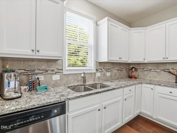 a kitchen with granite countertop white cabinets and white appliances