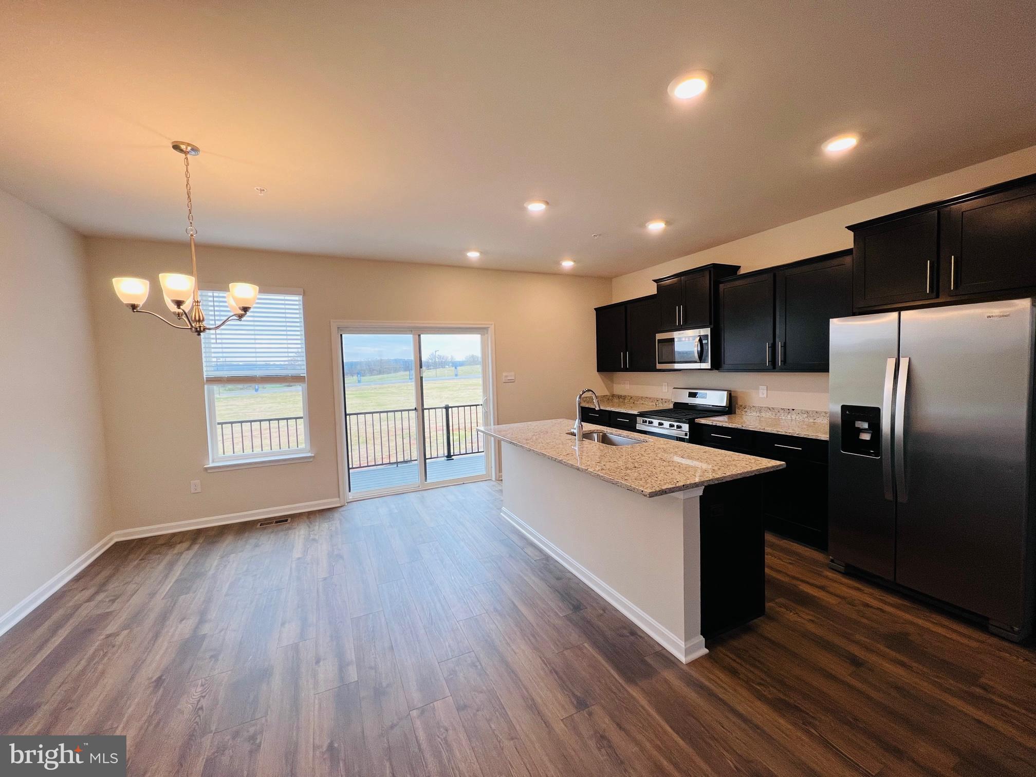 552 Union Street Frederick, MD 21701 - Photo 14 of 58 a kitchen with stainless steel appliances kitchen island granite countertop wooden floors and a sink