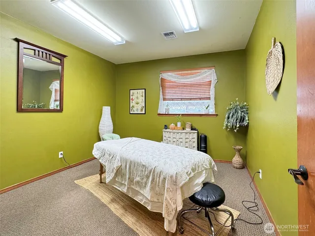 a bedroom with a bed and a painting on the wall