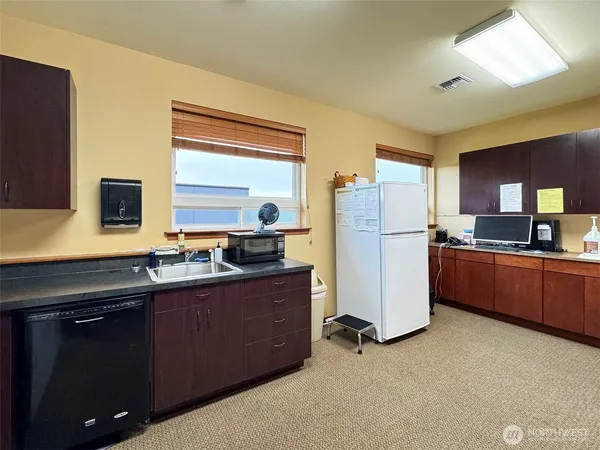 a kitchen with refrigerator and cabinets