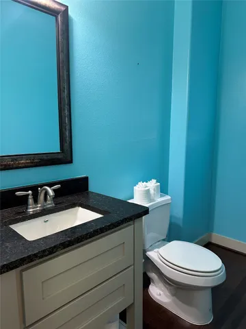 a bathroom with a granite countertop toilet and sink
