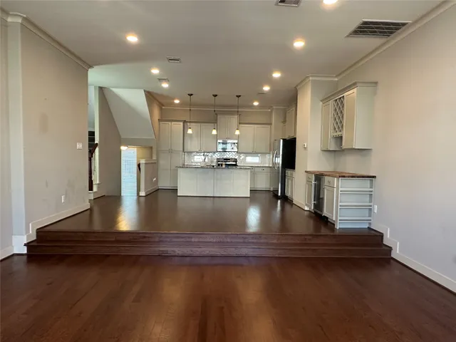 a view of a kitchen with kitchen island a counter top space a sink and cabinets