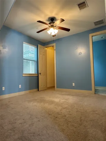 a view of an empty room with a chandelier fan