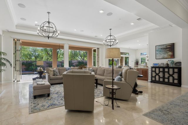 a living room with furniture a chandelier and a dining table