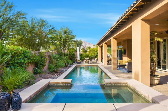 a outdoor space with the couches and dining table with the garden view