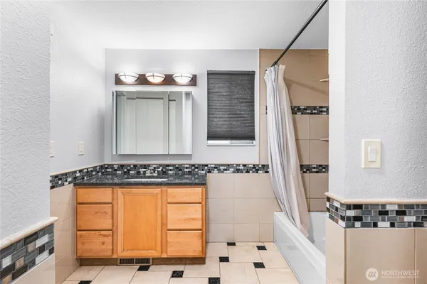 a bathroom with a tub a sink and a mirror