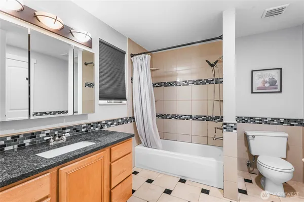 a bathroom with a granite countertop sink toilet and shower